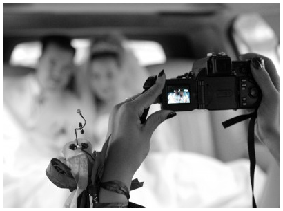 photographer taking pictures to a couple in wedding limo